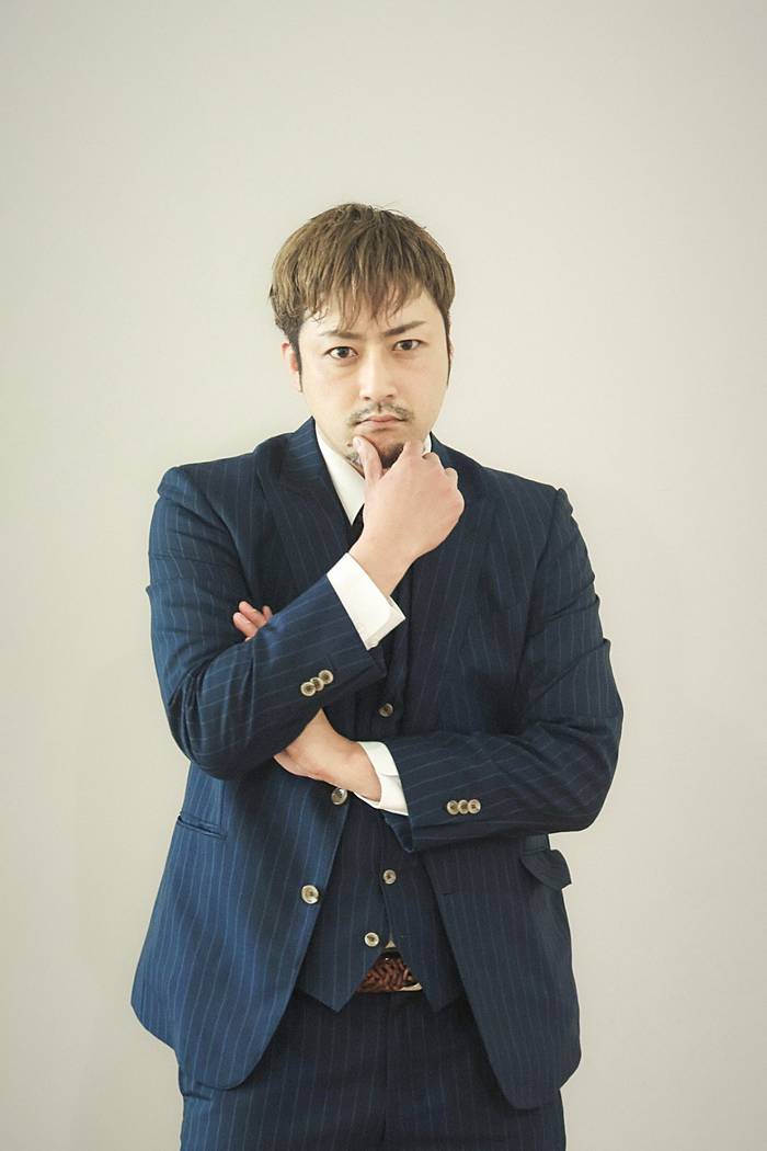 スタジオ、思案顔のネイビーストライプスーツ